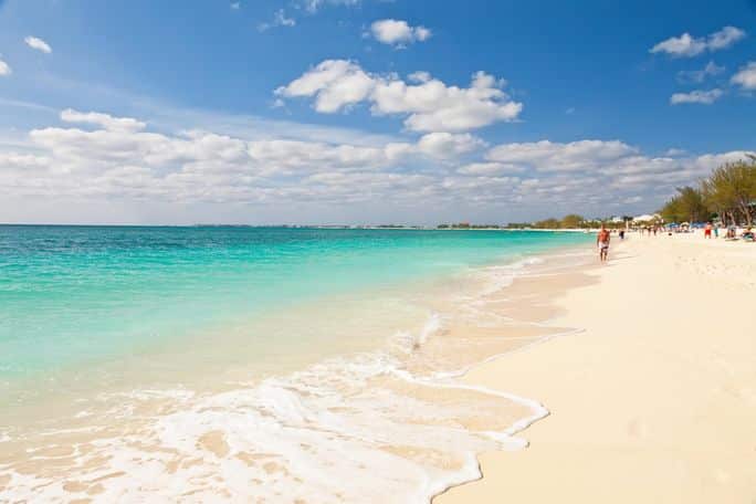 Tourists enjoying Seven Mile Beach in Grand Cayman